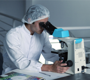 Scientist looking into a microscope.